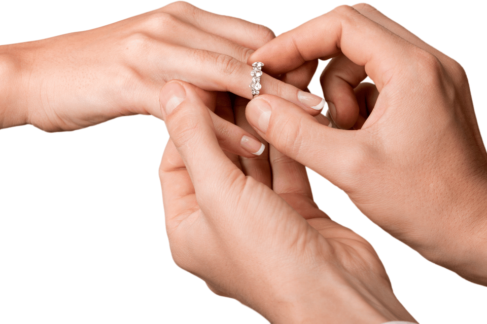 Diamond and engagement rings Columbus, OH - a bride's hand with a diamond engagement ring and wedding band on top of a groom's hand