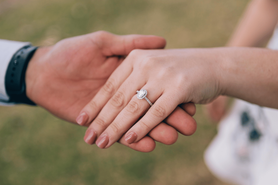 Engagement Rings Jewelers Near Me Dayton, OH - a man holding a woman's hand showing off a diamond engagement ring